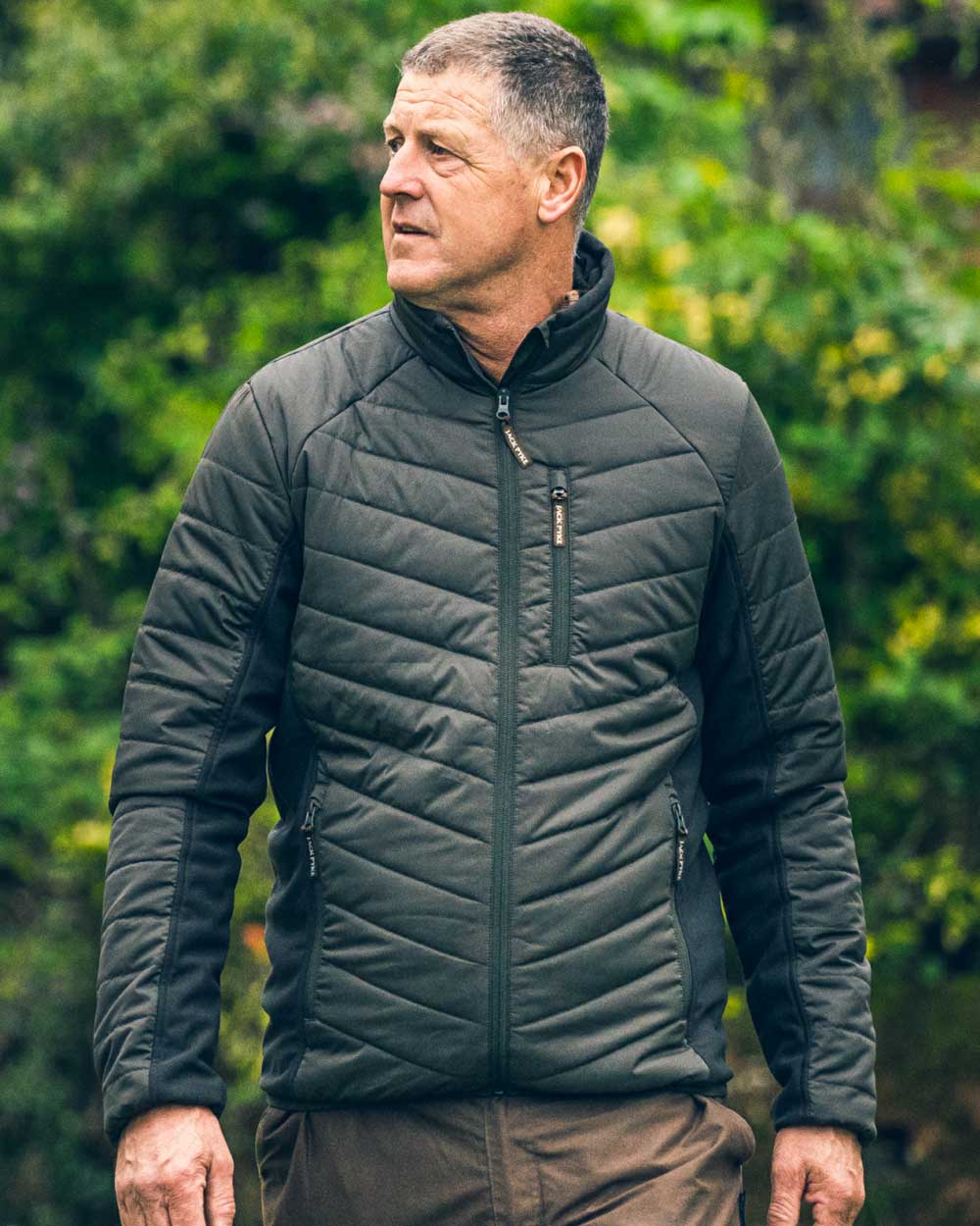 Green coloured Jack Pyke Hybrid Jacket on blurry background #colour_green