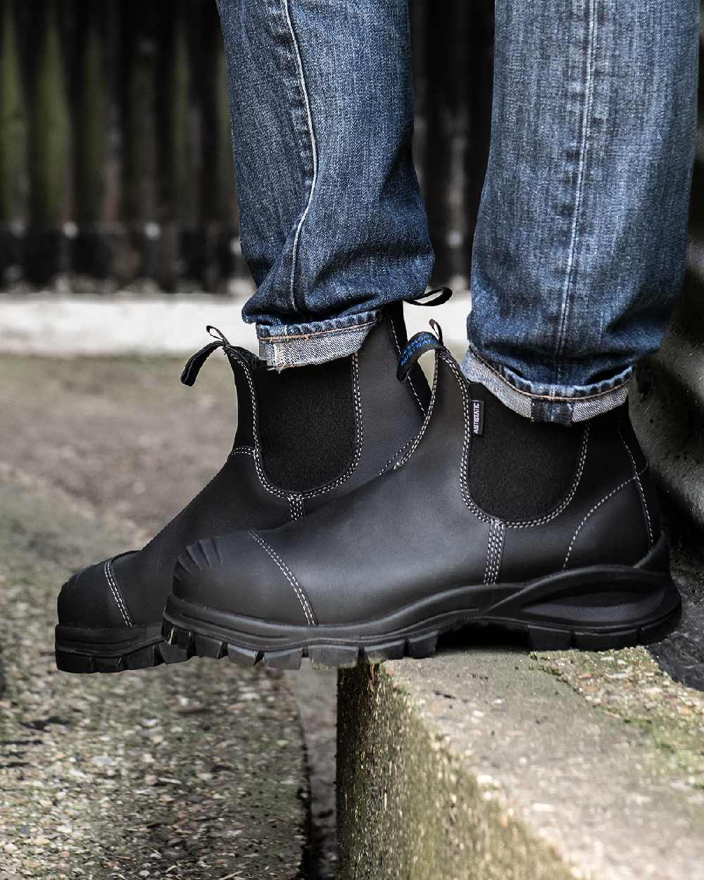 Black coloured Blundstone 910 Black Platinum Safety Boots on street background #colour_black