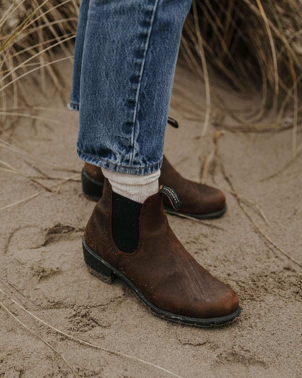 Antique Brown coloured Blundstone Womens 1673 Chelsea Boots on sand background #colour_antique-brown