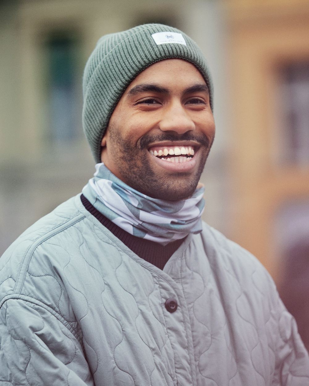 Silversage Coloured Buff Drisk Knitted Beanie on blurry background #colour_silversage