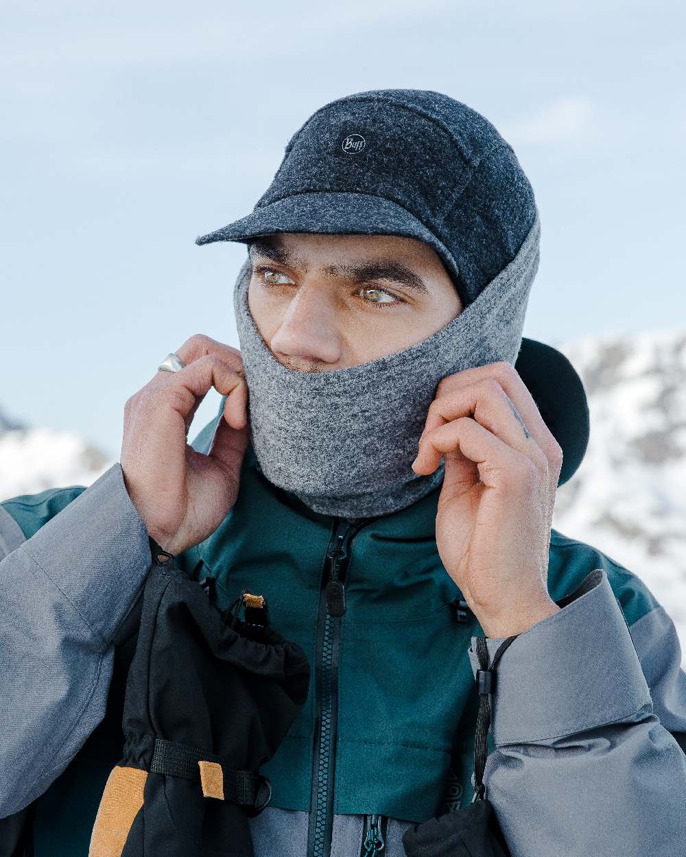 Grey Coloured Buff Merino Fleece Neck Warmer on snow background #colour_grey