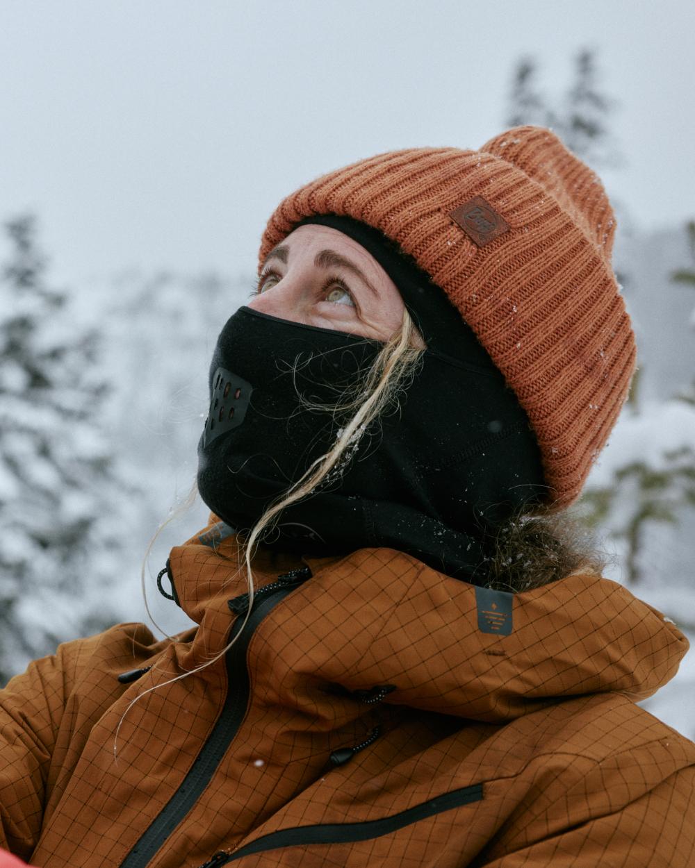 Black Coloured Buff Merino Lightweight Balaclava on snow background #colour_black