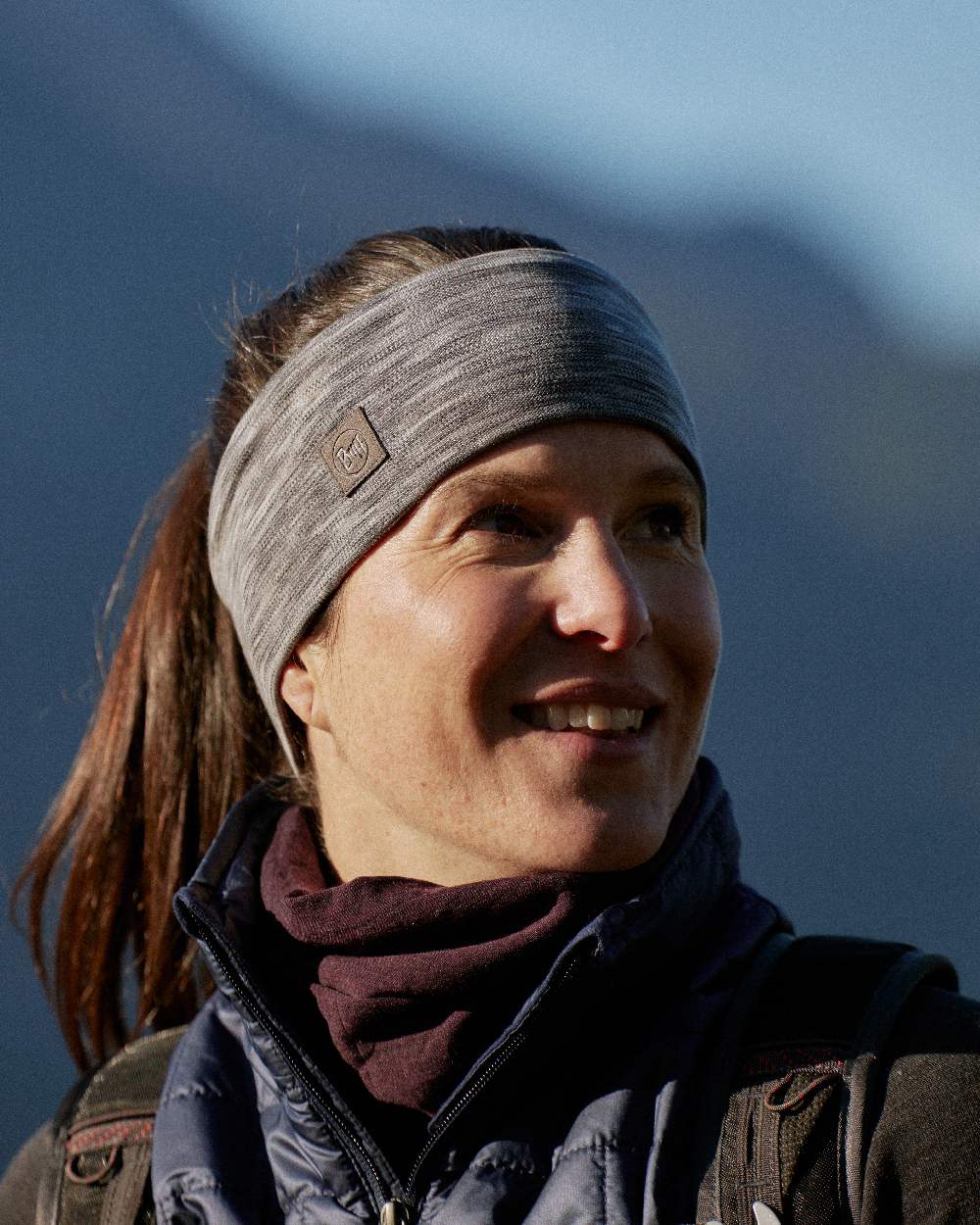Fog Grey Coloured Buff Merino Wide Headband on blurry background #colour_fog-grey
