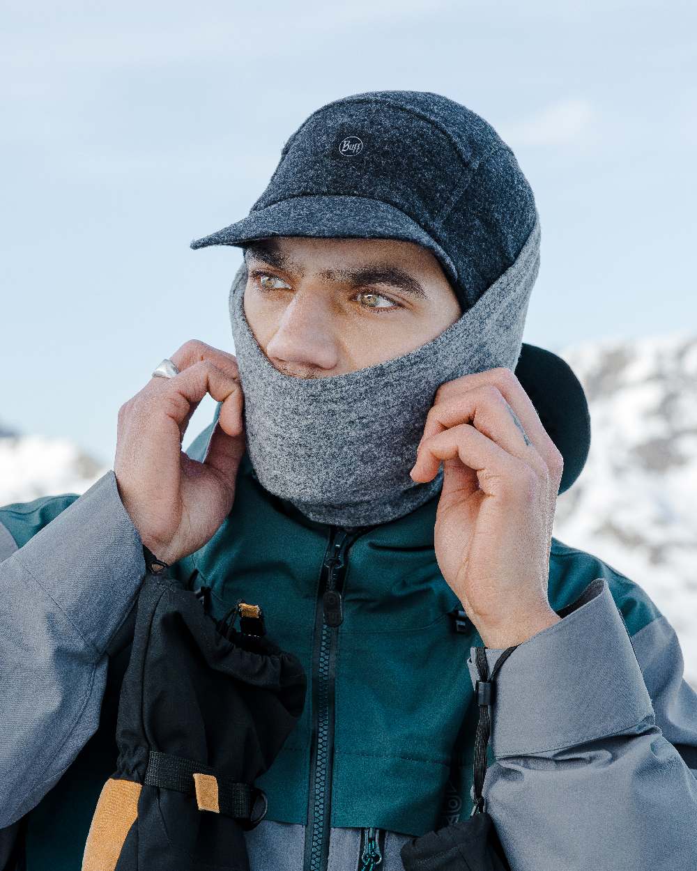 Black Coloured Buff Pack Merino Fleece Cap on snow background #colour_black