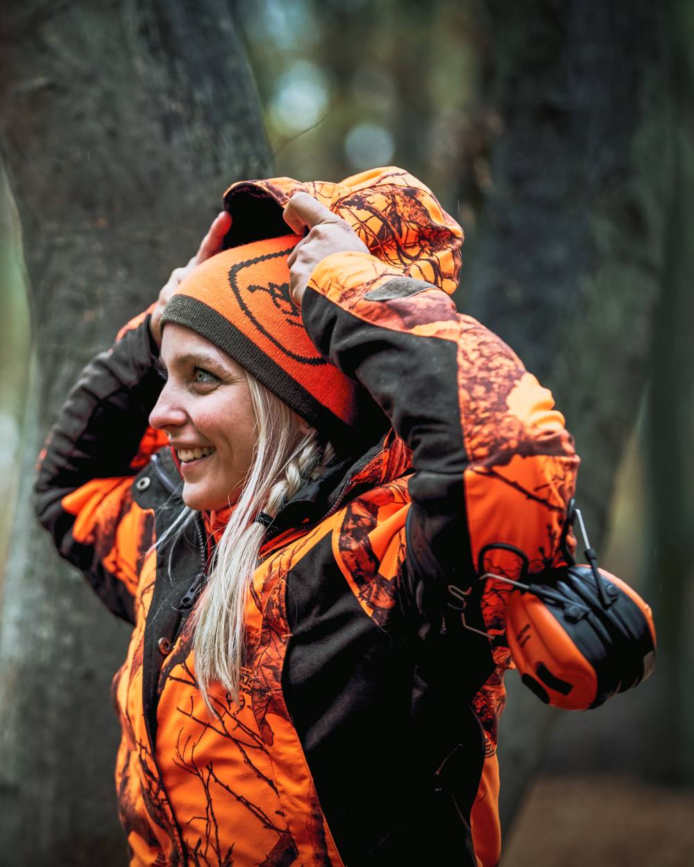 Orange Green coloured Deerhunter Cumberland Reversible Beanie on tree background #colour_orange-green