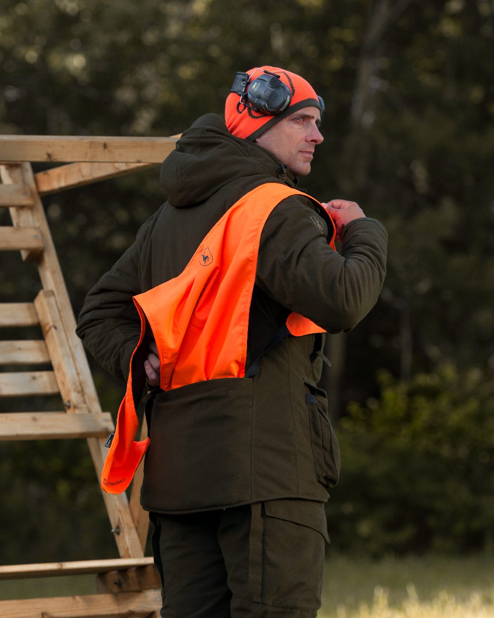 Orange Green coloured Deerhunter Cumberland Reversible Beanie on blurry background #colour_orange-green