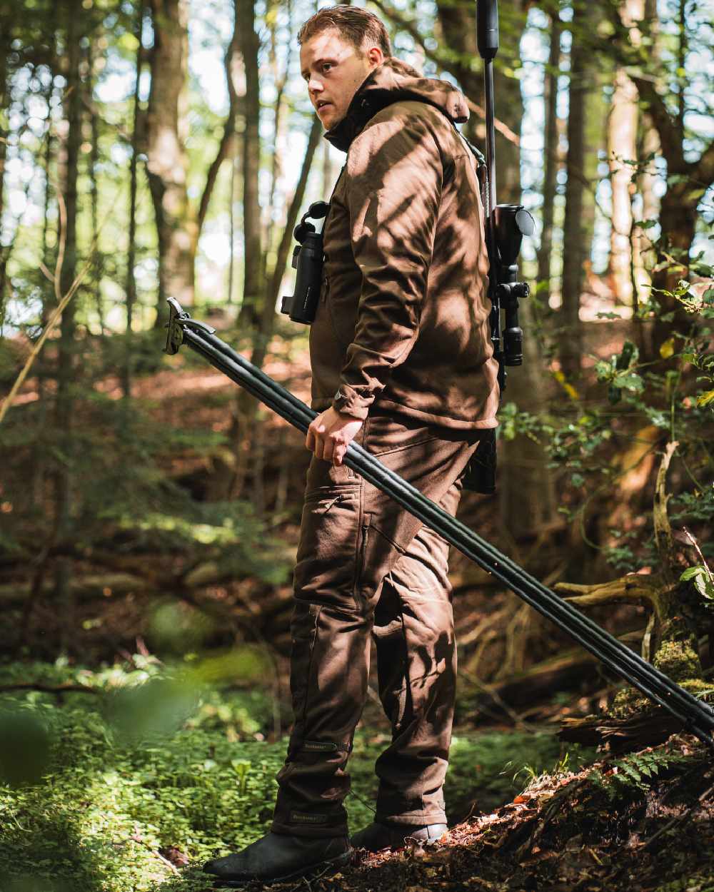 Art Green coloured Deerhunter Excape Softshell Trousers on forest background #colour_art-green