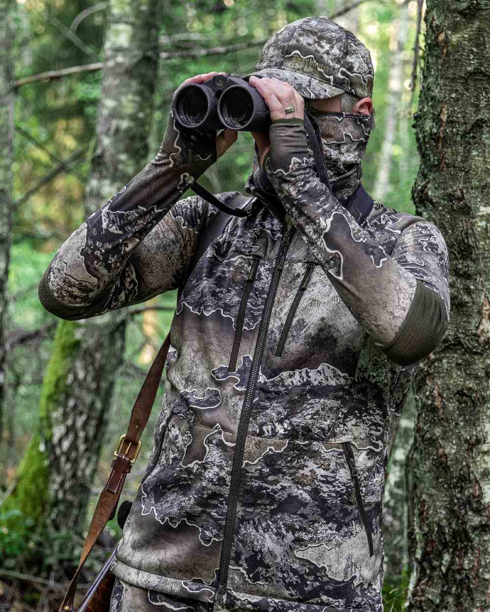 Realtree Excape coloured Deerhunter Excape Softshell Waistcoat on forest background #colour_realtree-excape