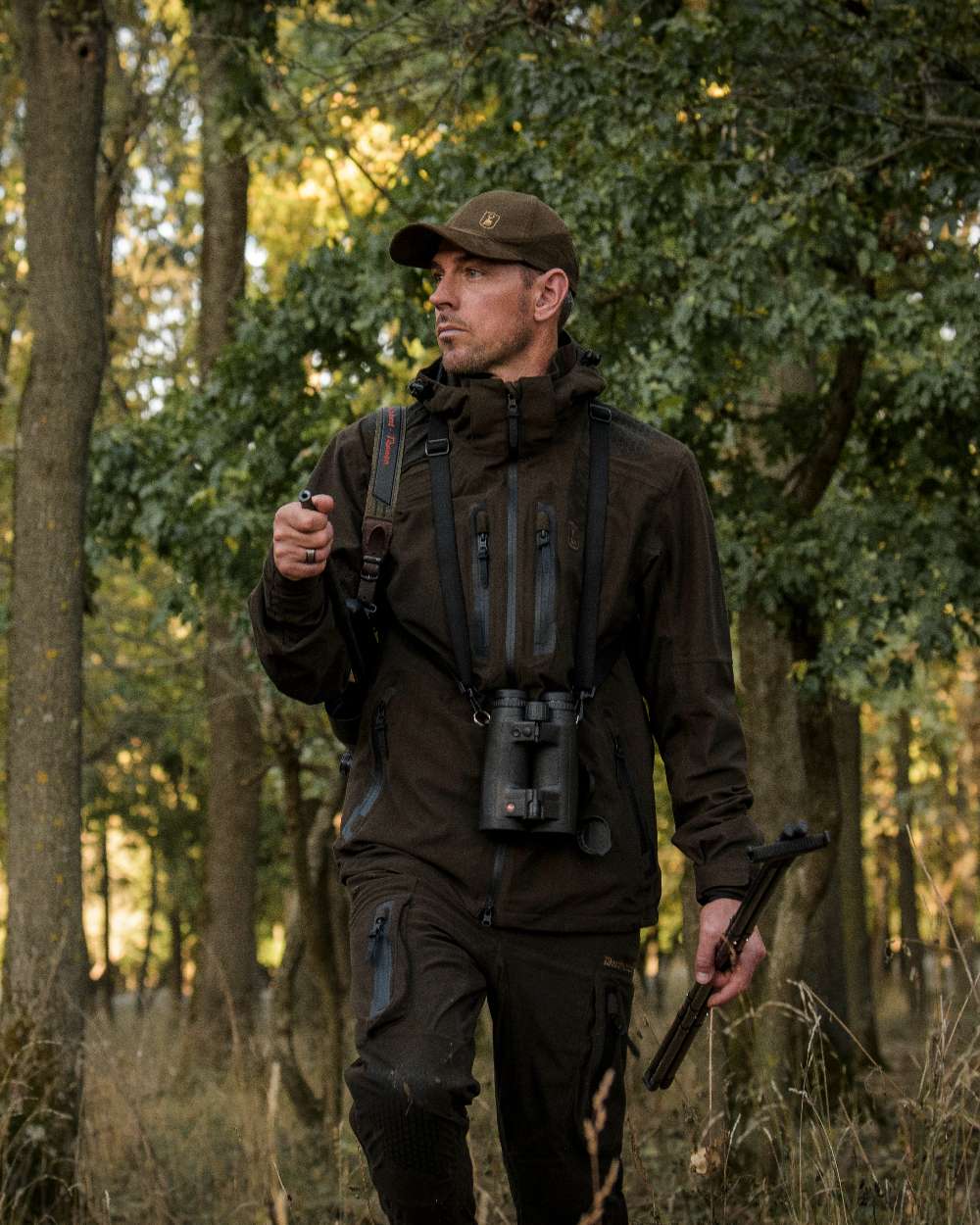 Wood coloured Deerhunter Game Pro Light Trousers on forest background #colour_wood
