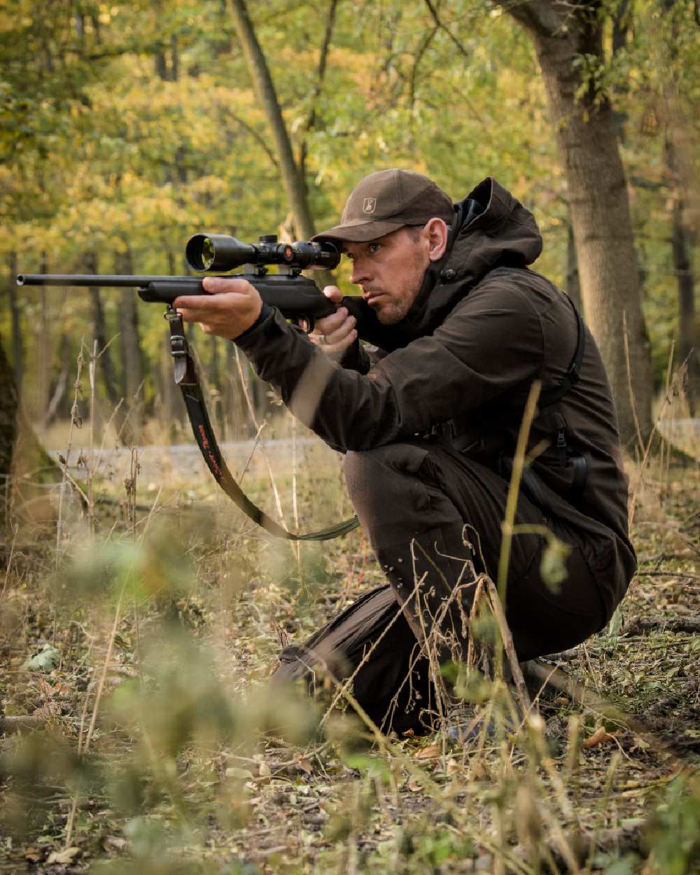 Wood coloured Deerhunter Game Pro Light Trousers on forest background #colour_wood