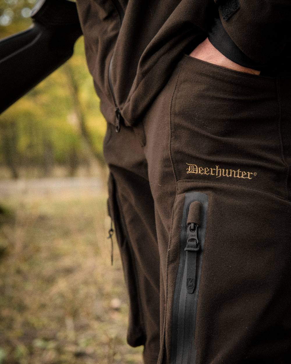 Wood coloured Deerhunter Game Pro Light Trousers on blurry background #colour_wood