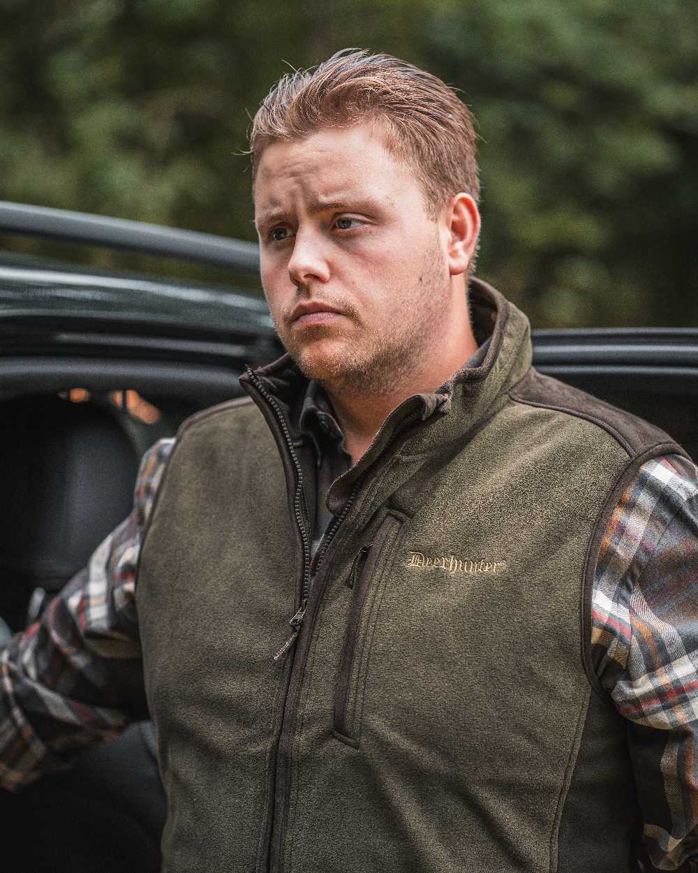 Graphite Green coloured Deerhunter Gamekeeper Bonded Fleece Waistcoat on blurry background #colour_graphite-green
