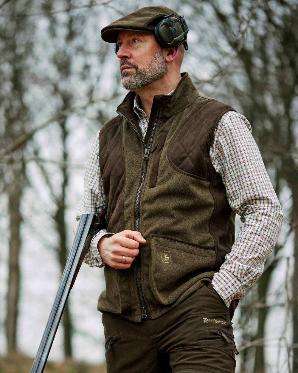 Graphite Green Coloured Deerhunter Gamekeeper Shooting Waistcoat on forest background #colour_graphite-green