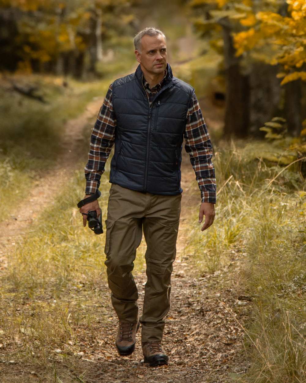 Dark Blue Coloured Deerhunter Heat Padded Waistcoat on forest background #colour_dark-blue