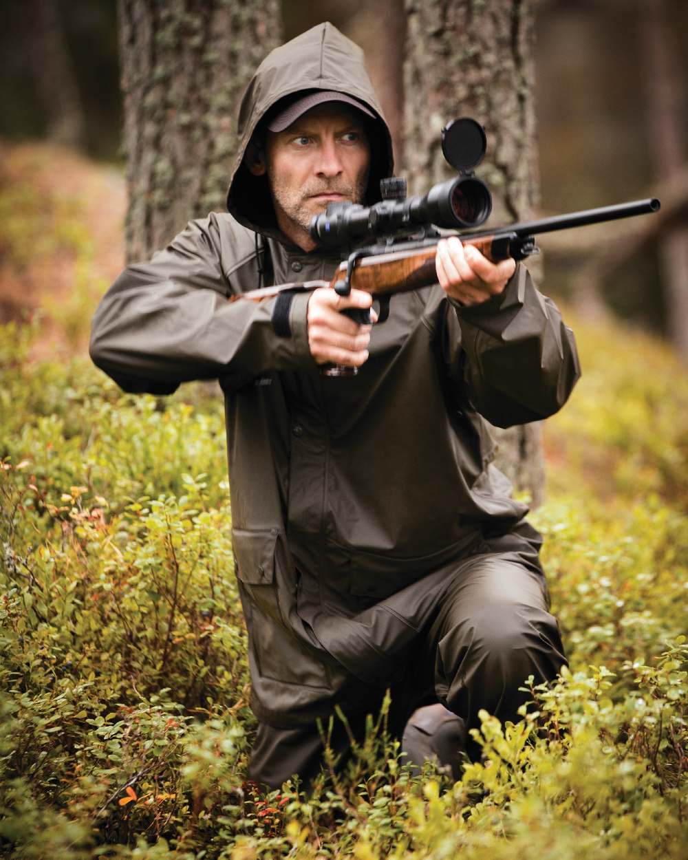 Art Green coloured Deerhunter Hurricane Rain Jacket on forest background #colour_art-green