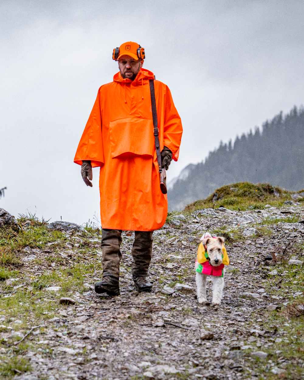 Orange coloured Deerhunter Hurricane Rain Poncho on mountain background #colour_orange