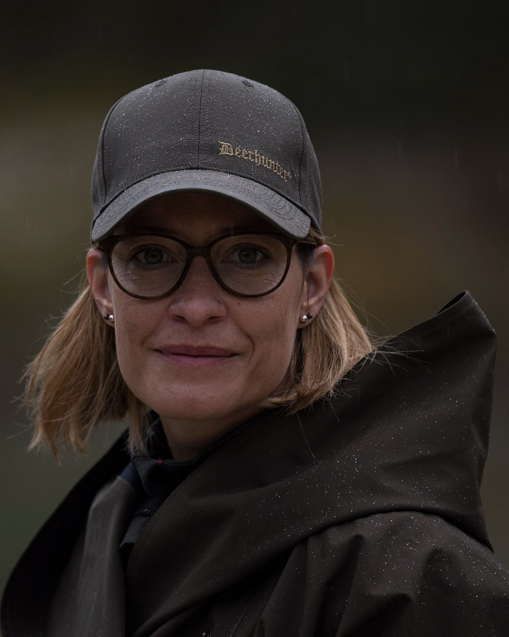 Canteen Coloured Deerhunter Ladies Waterproof Rain Poncho on blurry background #colour_canteen