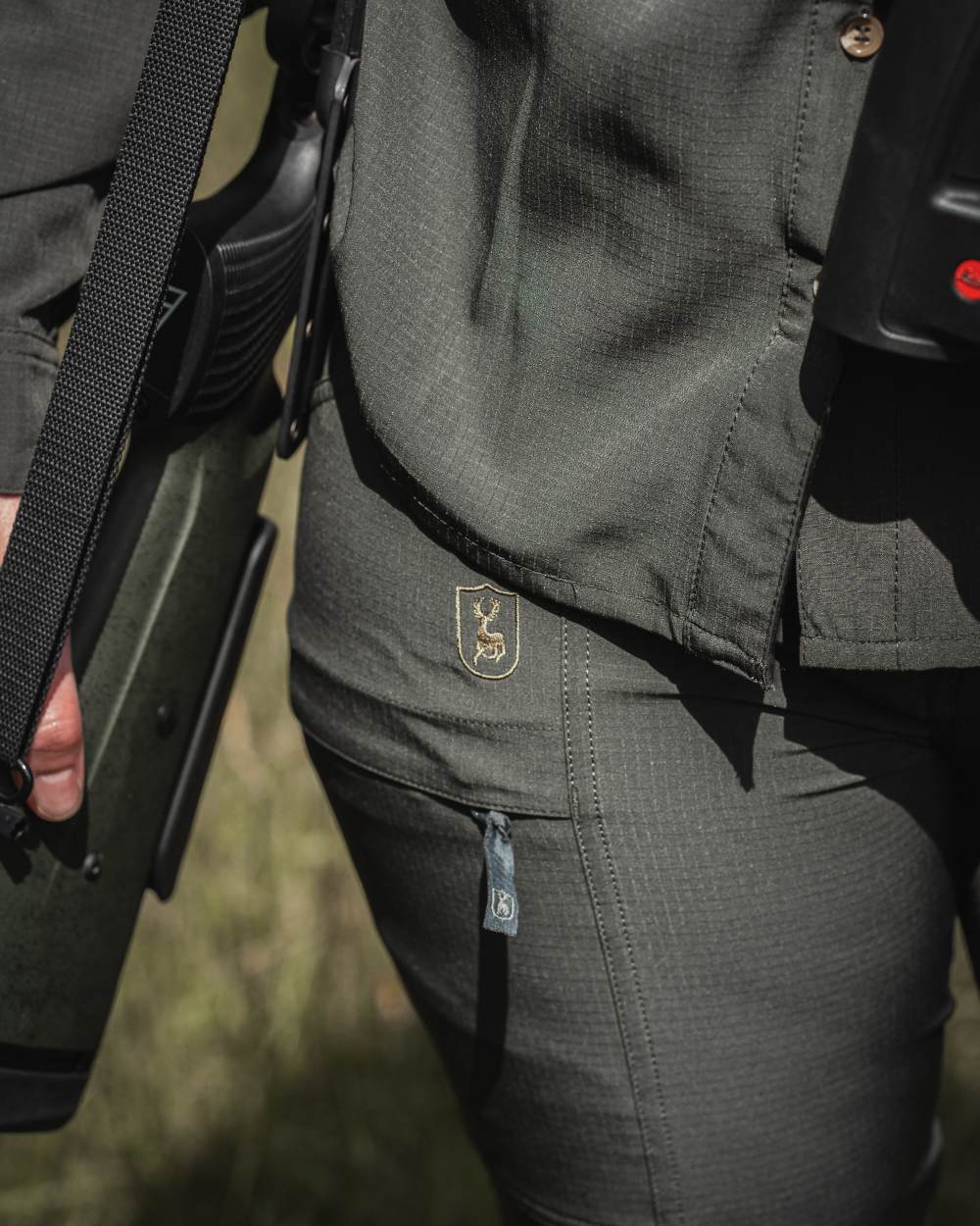 Forest Green coloured Deerhunter Lady Canopy Trousers on blurry background #colour_forest-green