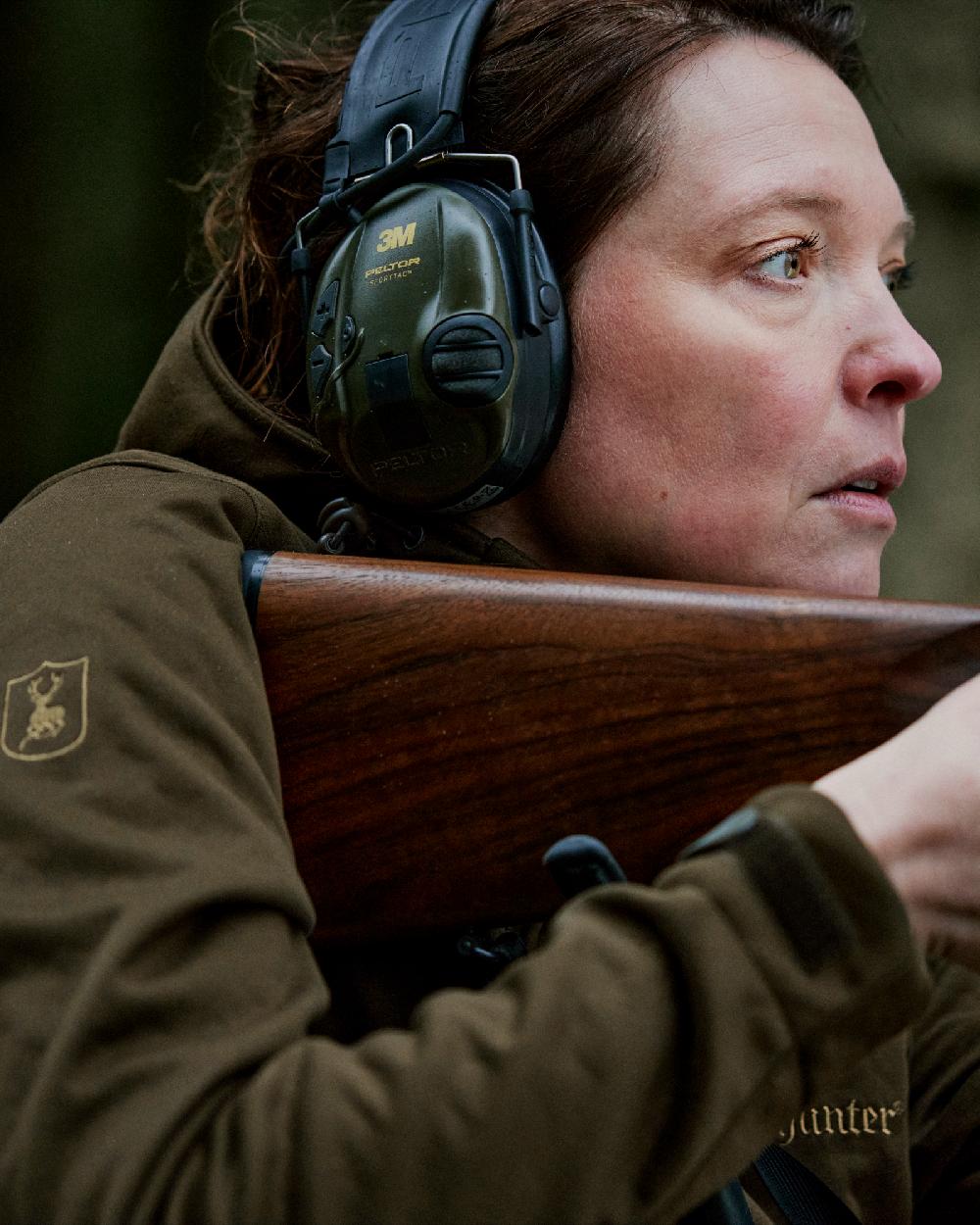 Art Green coloured Deerhunter Lady Excape Softshell Jacket on blurry background #colour_art-green