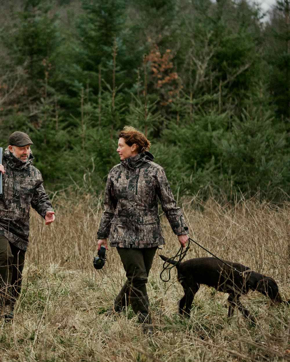 Peat coloured Deerhunter Lady Gabby Waterproof Boot Trousers on forest background #colour_peat