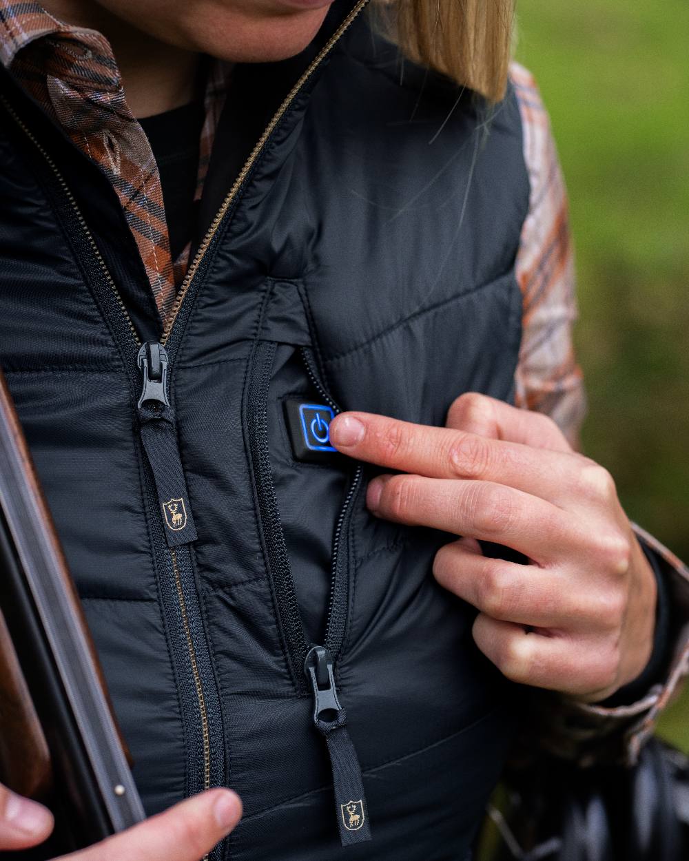 Dark Blue Coloured Deerhunter Lady Heat Padded Waistcoat on blurry background #colour_dark-blue