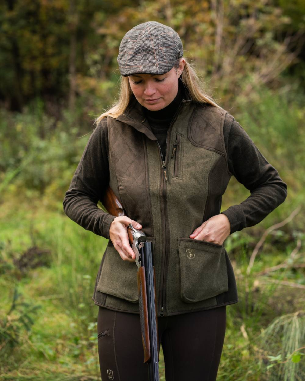 Graphite Green coloured Deerhunter Lady Pam Shooting Waistcoat on forest background #colour_graphite-green