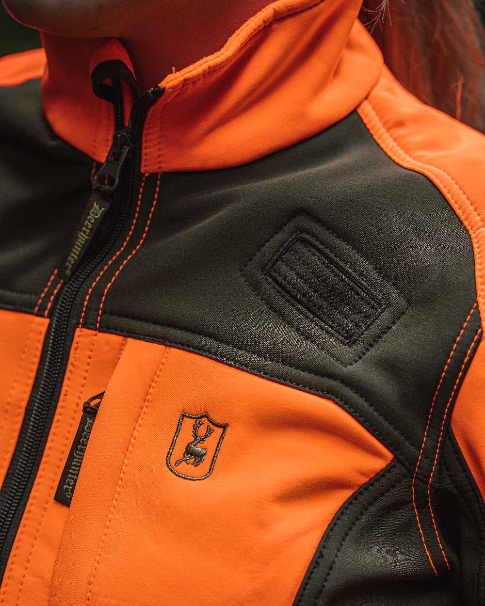 Orange coloured Deerhunter Lady Roja Softshell Jacket on blurry background #colour_orange