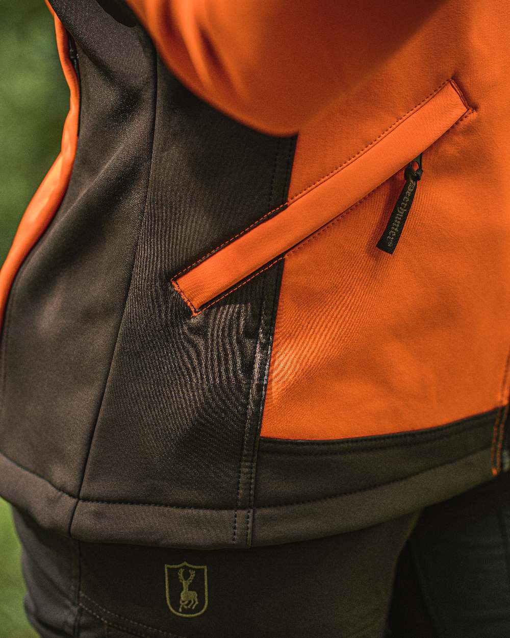 Orange coloured Deerhunter Lady Roja Softshell Jacket on blurry background #colour_orange