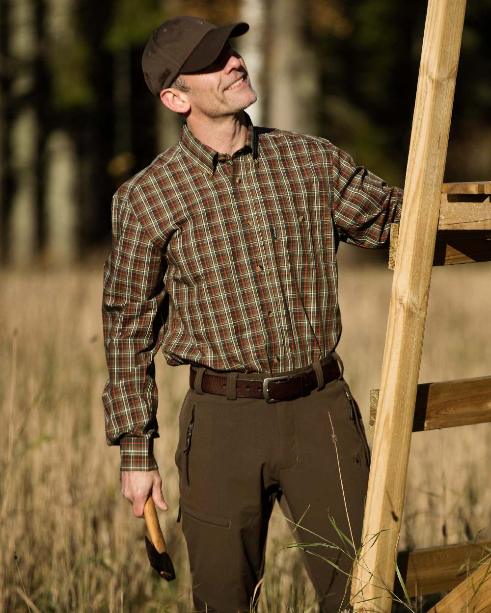 Dark Brown coloured Deerhunter Leather Belt on grassy background #colour_dark-brown