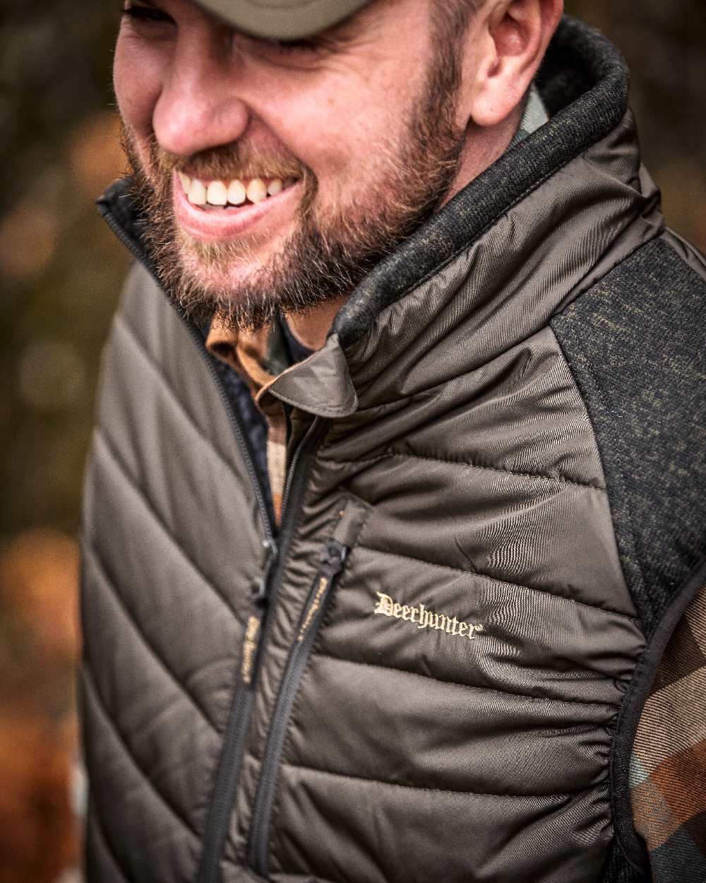 Brown Leaf Coloured Deerhunter Moor Padded Waistcoat with Knit on blurry background #colour_brown-leaf