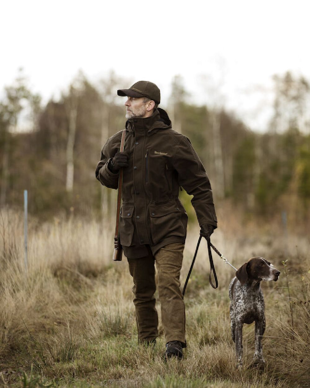 Peat Coloured Deerhunter PRO Gamekeeper Jacket on forest background #colour_peat