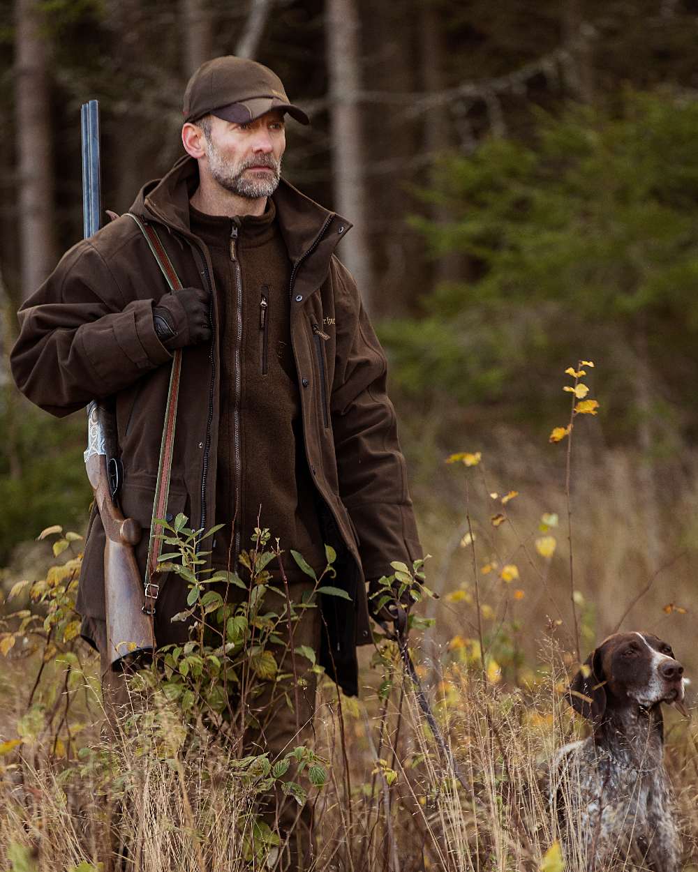 Peat Coloured Deerhunter PRO Gamekeeper Jacket on forest background #colour_peat