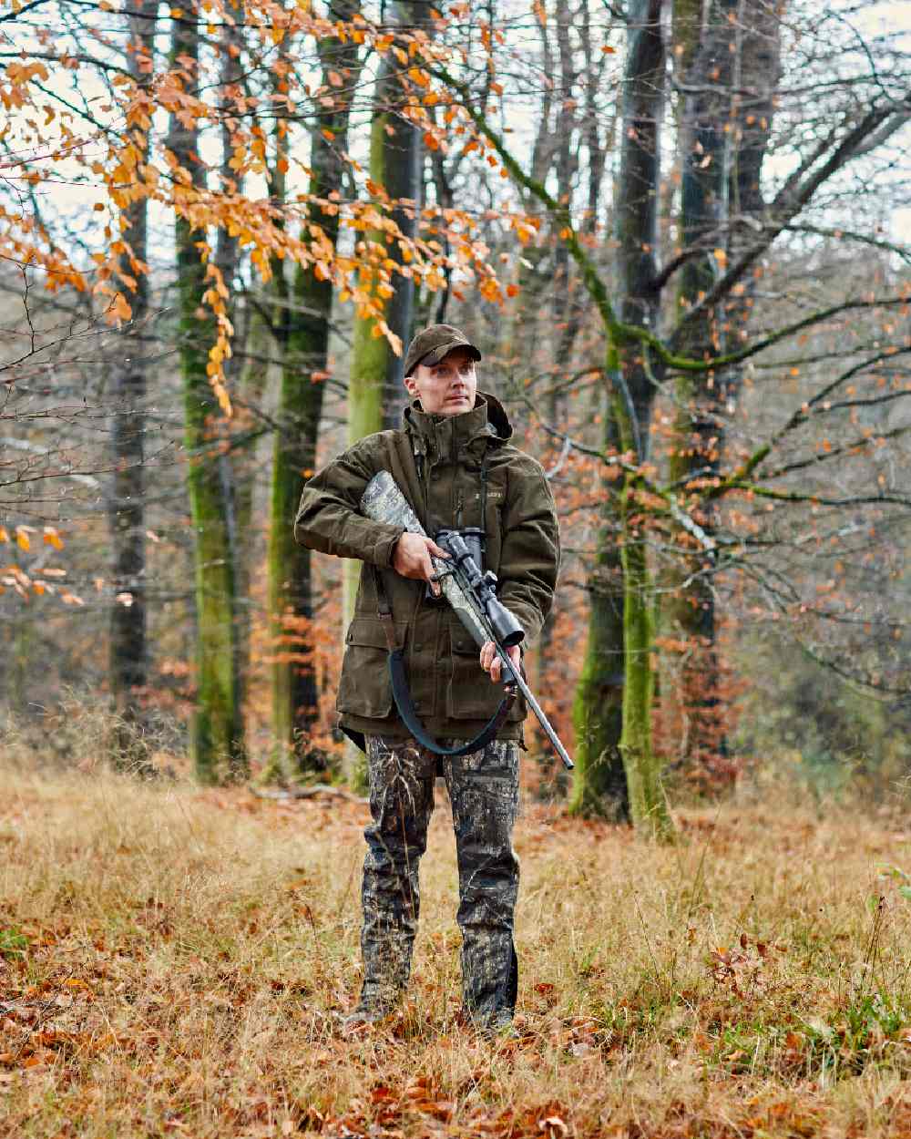Peat Coloured Deerhunter PRO Gamekeeper Jacket on forest background #colour_peat