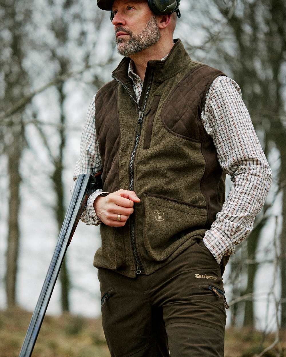 Peat Coloured Deerhunter Pro Gamekeeper Boot Trousers on blurry background #colour_peat