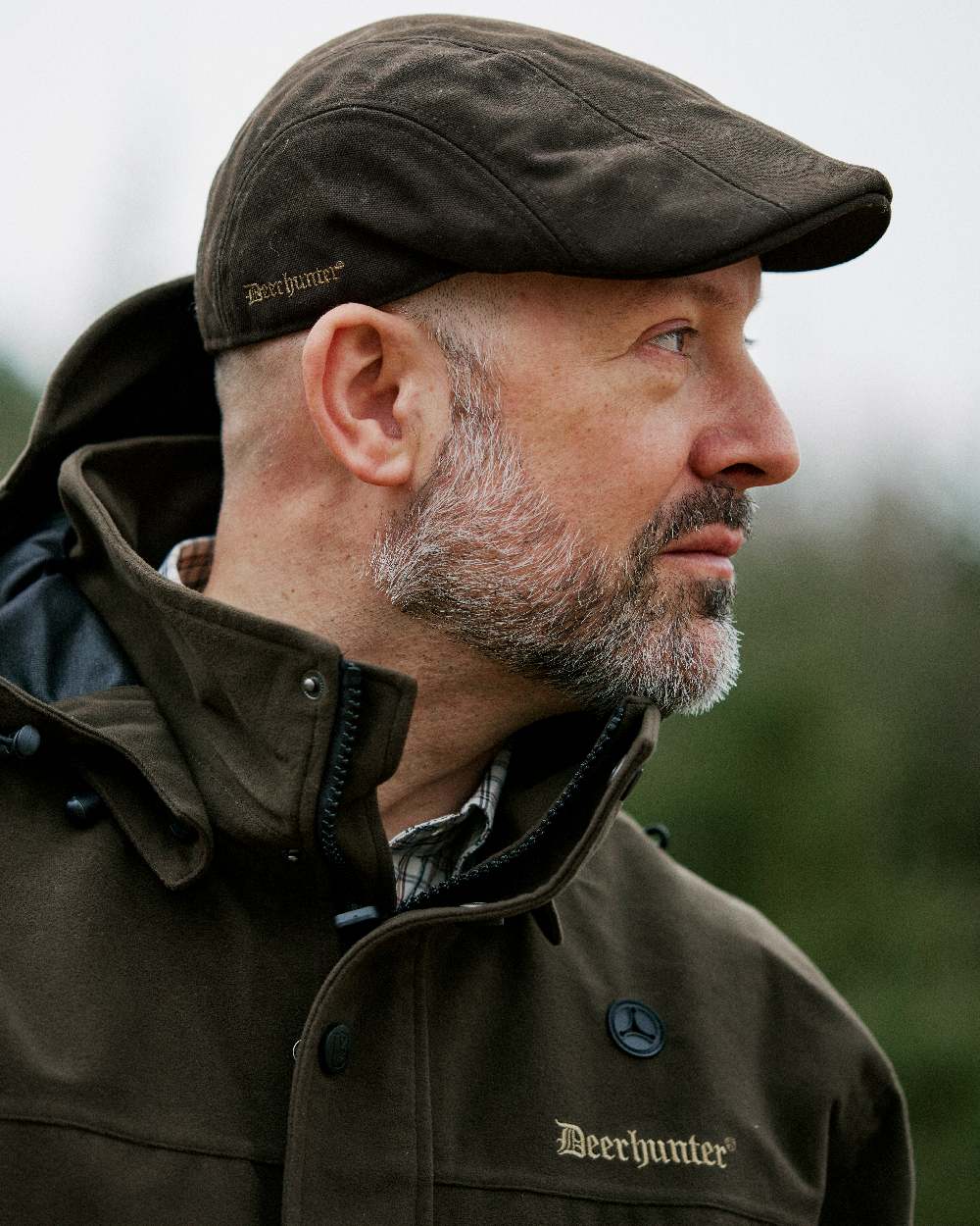 Peat coloured Deerhunter Pro Gamekeeper Flatcap on blurry background #colour_peat