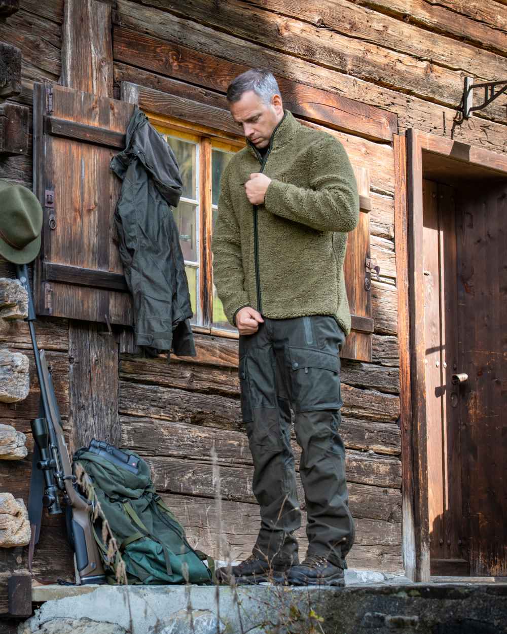 Elmwood coloured Deerhunter Ram Trousers with Reinforcement on wooden wall background #colour_elmwood