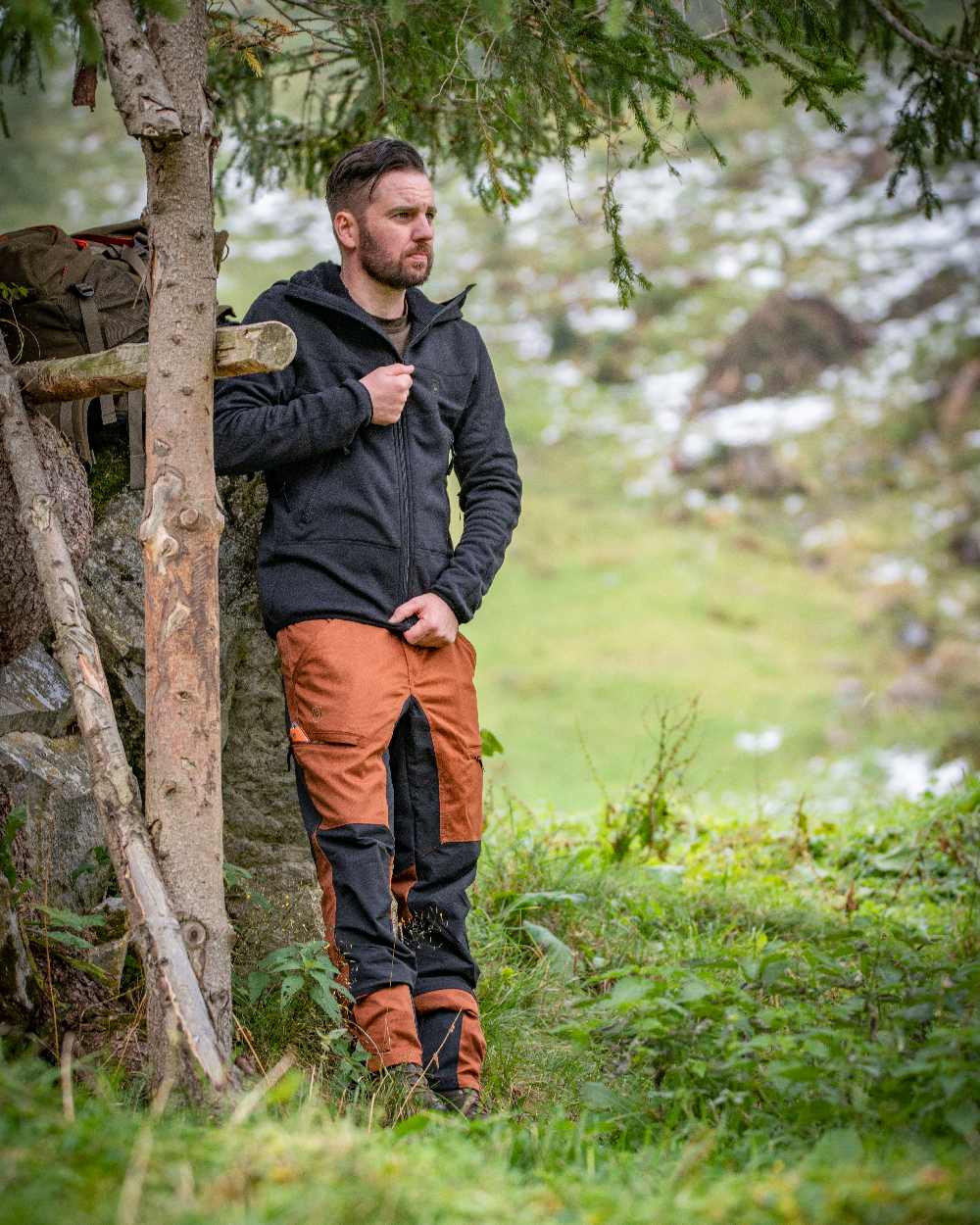 Burnt Orange Coloured Deerhunter Rogaland Contrast Stretch Trousers on forest background #colour_burnt-orange