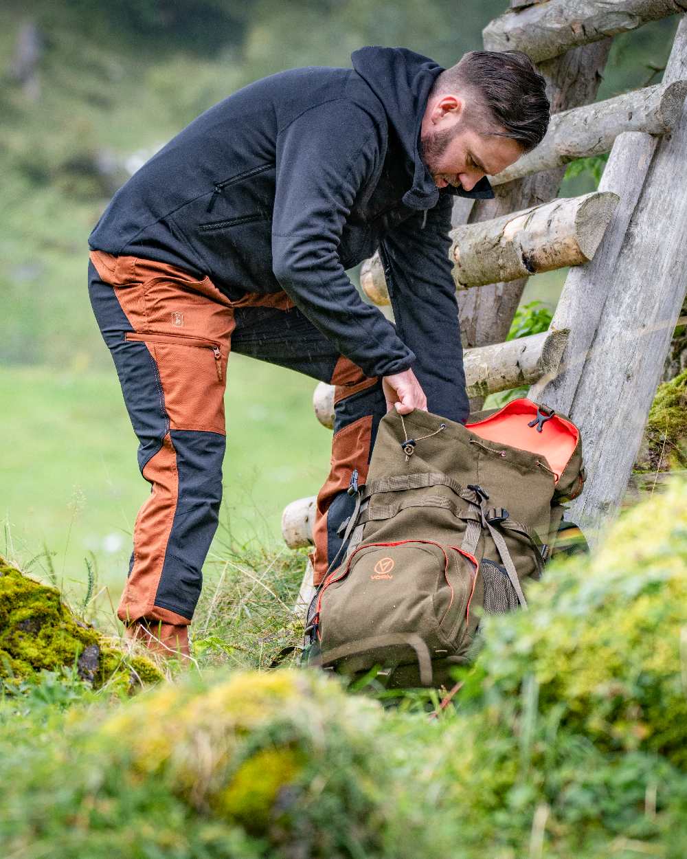 Burnt Orange Coloured Deerhunter Rogaland Contrast Stretch Trousers on forest background #colour_burnt-orange