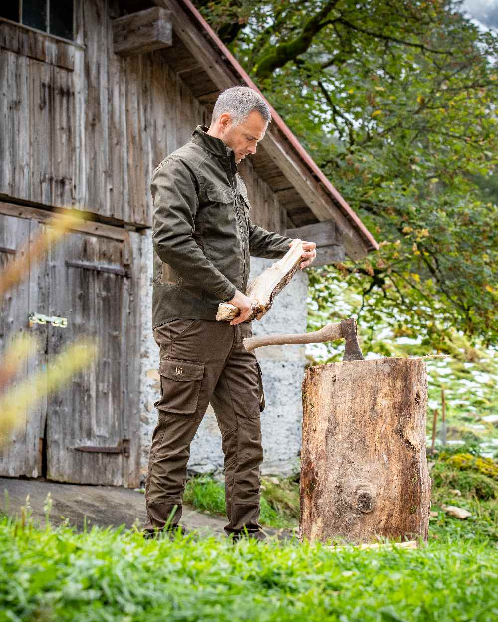 Fallen Leaf Coloured Deerhunter Rogaland Stretch Trousers on log house background #colour_fallen-leaf