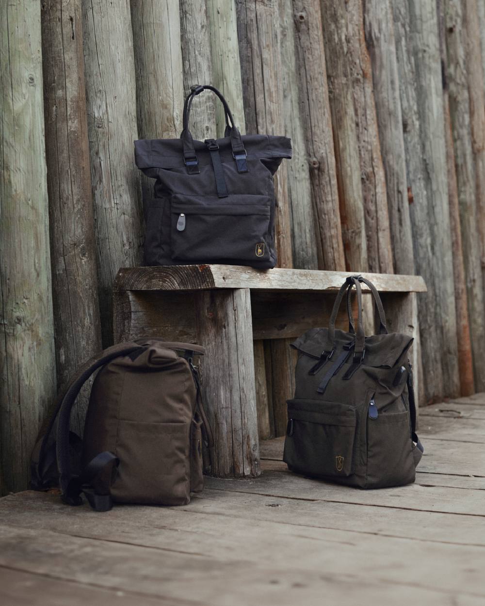 Black Ink coloured Deerhunter Rolltop Backpack on wooden wall background #colour_black-ink
