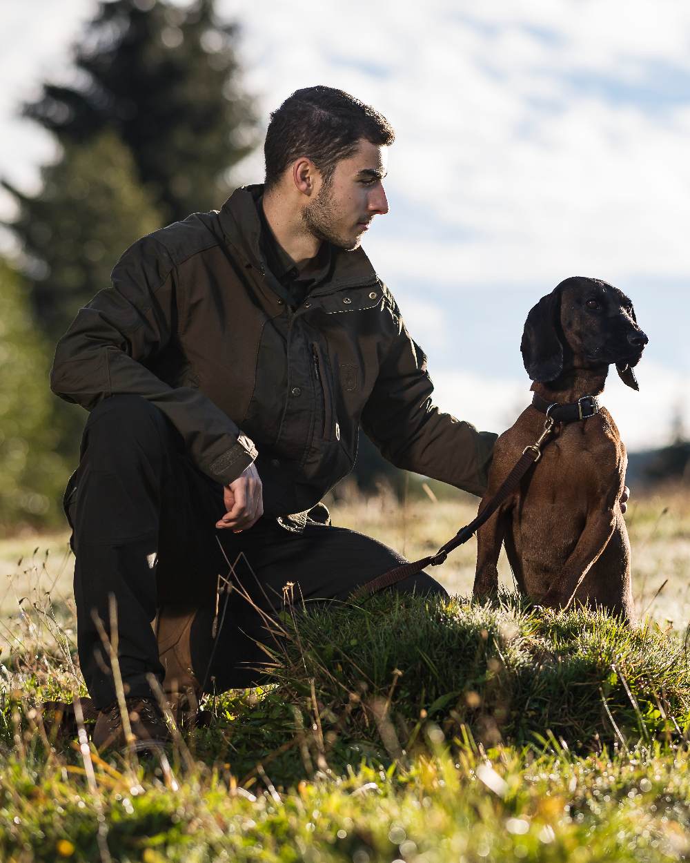 Black coloured Deerhunter Strike Full Stretch Trousers on forest background #colour_black