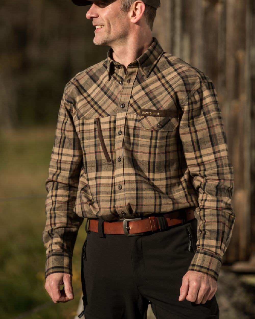Black coloured Deerhunter Strike Full Stretch Trousers on forest background #colour_black
