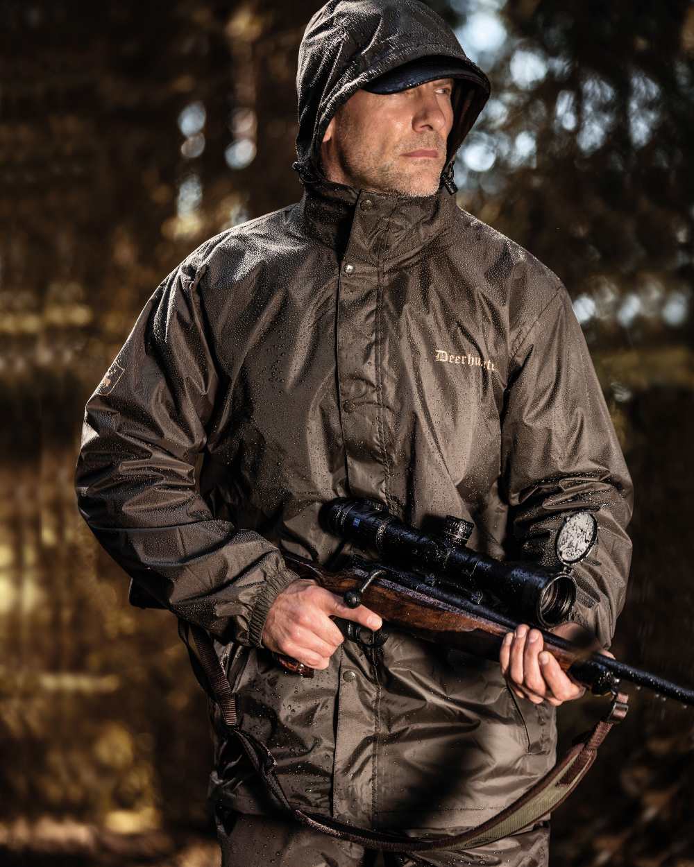 Timber coloured Deerhunter Survivor Packable Rain Jacket on forest background #colour_timber