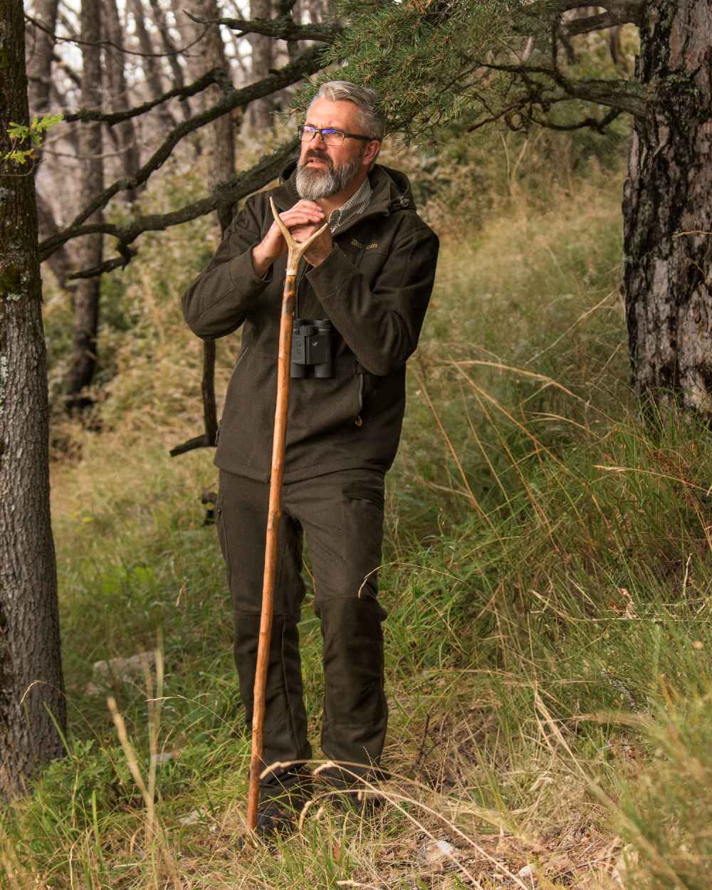 Loden Wood coloured Deerhunter Tatra Active Jacket on forest background #colour_loden-wood