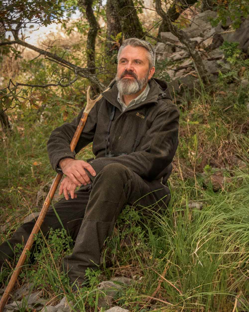 Loden Wood coloured Deerhunter Tatra Active Jacket on forest background #colour_loden-wood