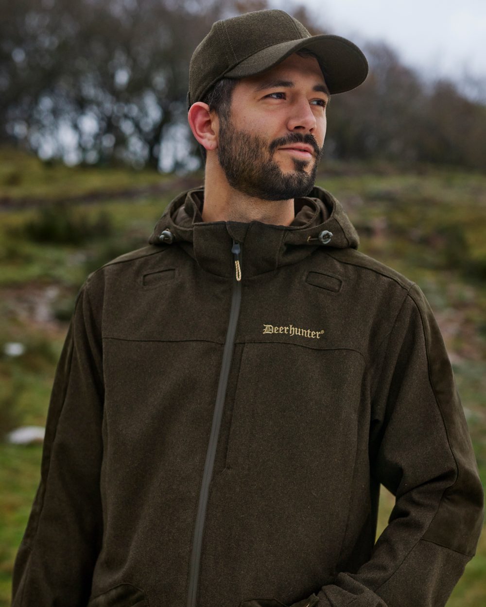 Loden Wood Coloured Deerhunter Tatra Jacket On A Forest Background #colour_loden-wood