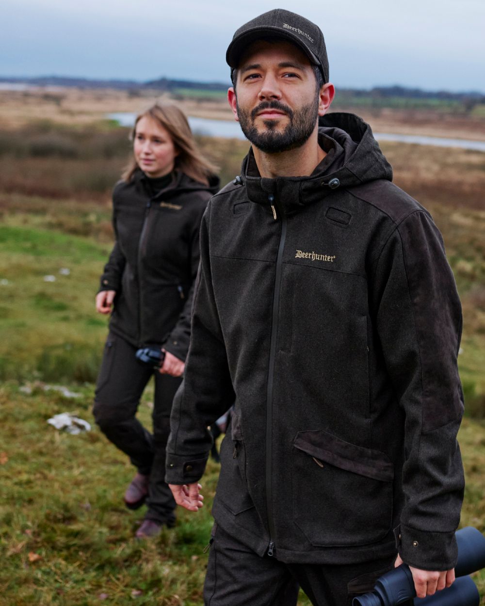 Loden Wood Coloured Deerhunter Tatra Jacket On A Forest Background #colour_loden-wood