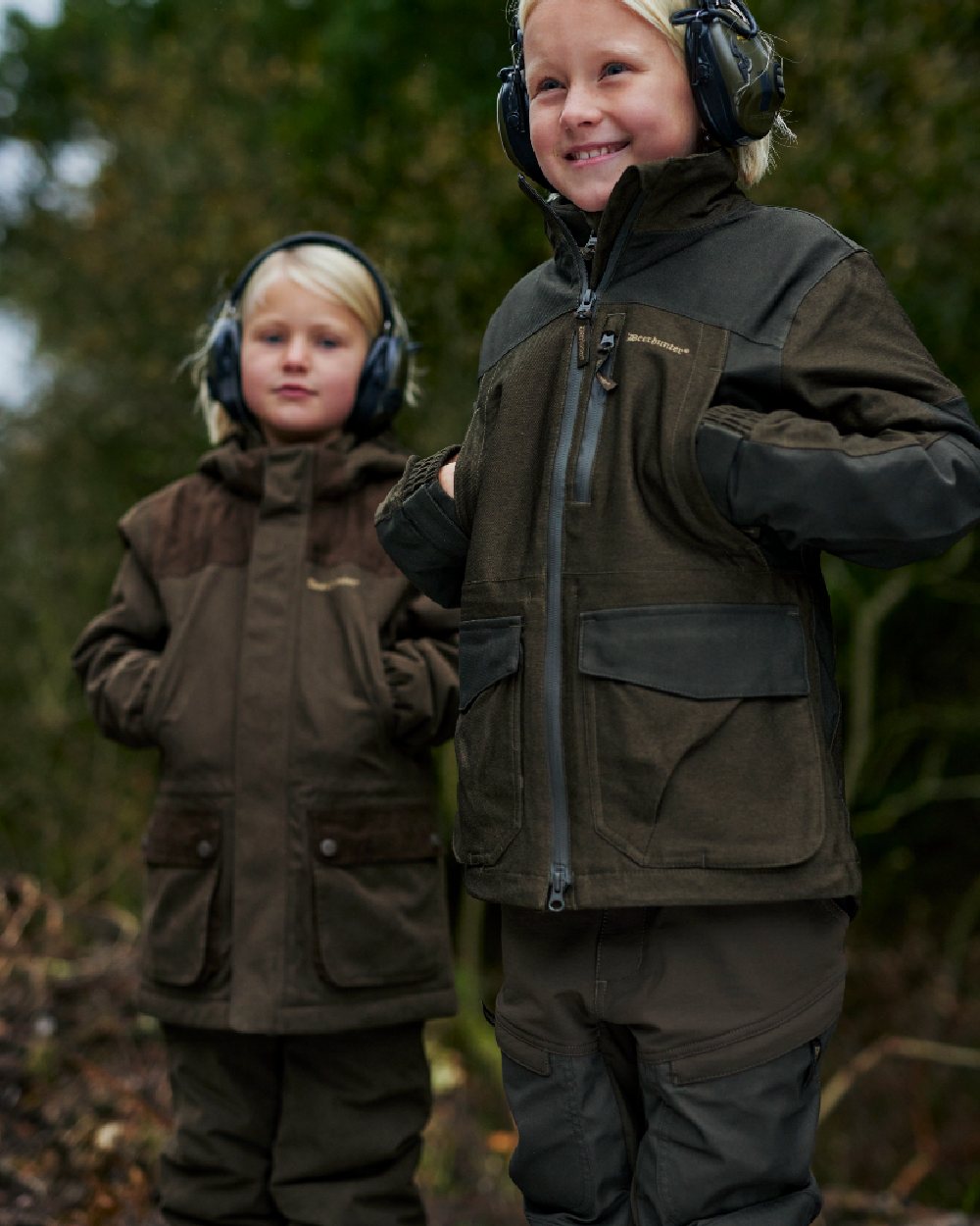 Dark Green coloured Deerhunter Sarek Shell Jacket With Hood on forest background #colour_dark-green