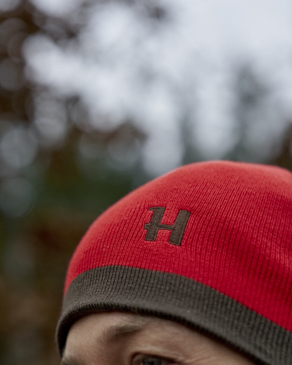 Shadow Brown Red Coloured Harkila Aspire Reversible Beanie on outdoor background #colour_shadow-brown-red