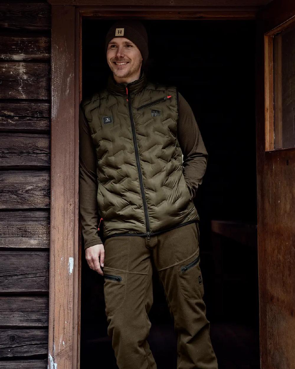 Willow Green Coloured Harkila Clim8 Insulated Waistcoat on outdoor background #colour_willow-green